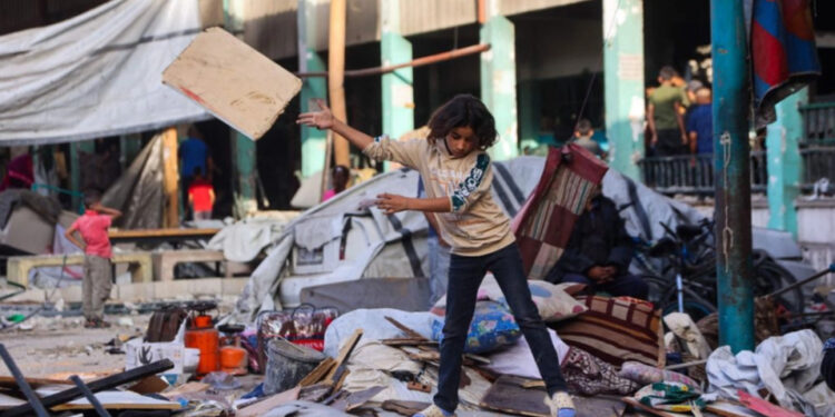 Niños levantan escombros en escuela bombardeada por Israel